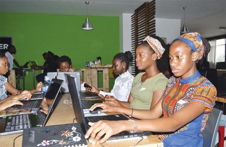 Women collaborating together at laptops in a community workshop