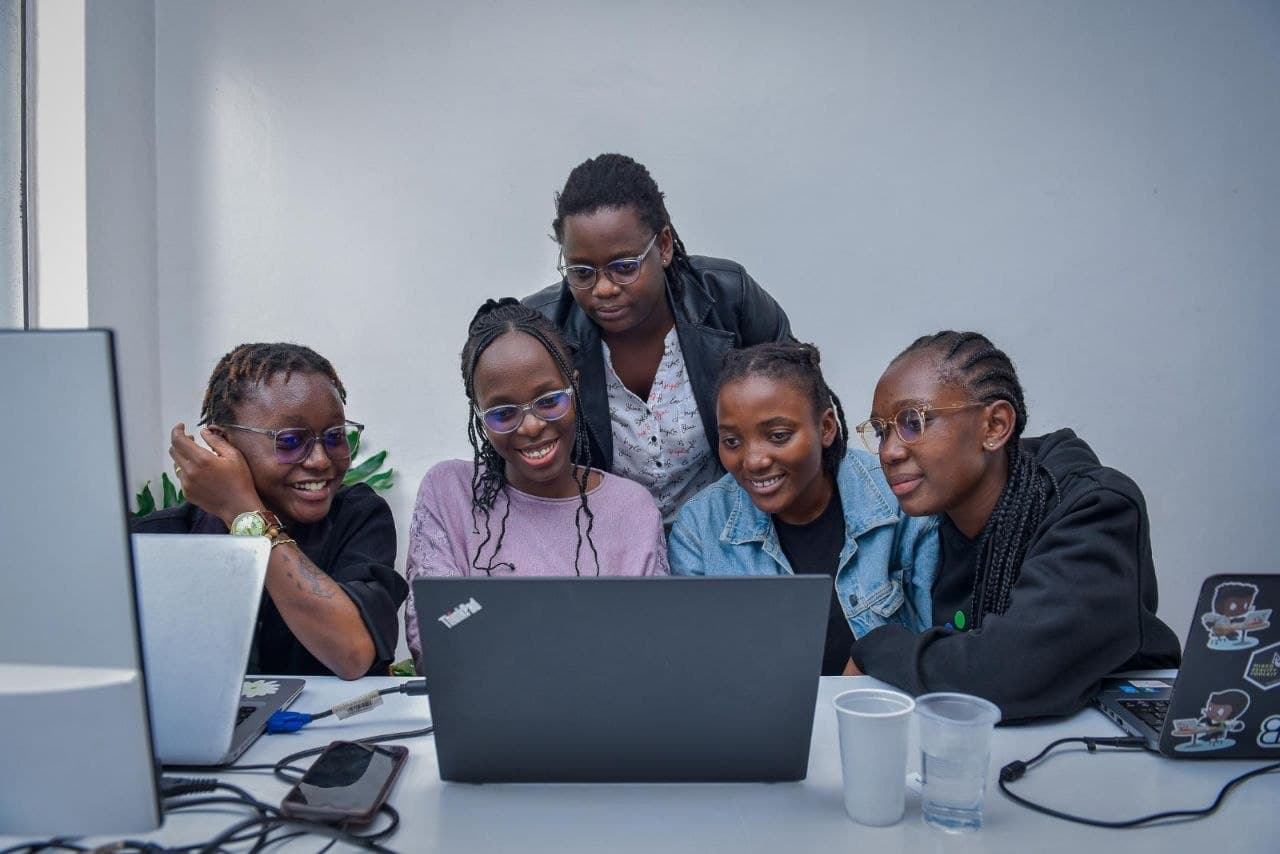 Tech4Her Global mentor guiding a mentee at a laptop
