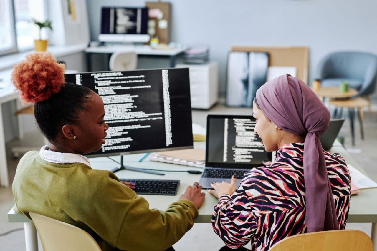 Two women working together at a laptop in a mentoring session
